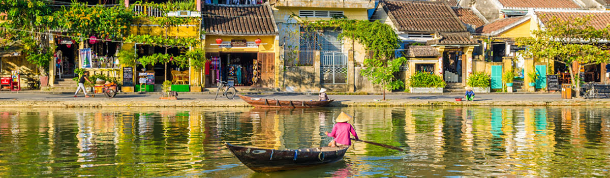 Locals paddling Vietnamese boats down river in Hoi An