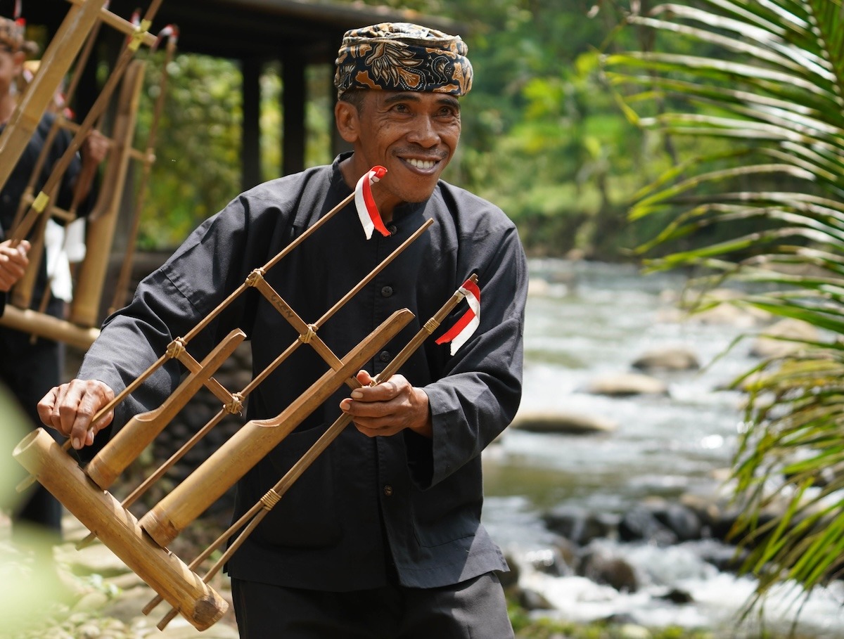 Seorang lelaki bermain Angklung, alat muzik tradisional Indonesia