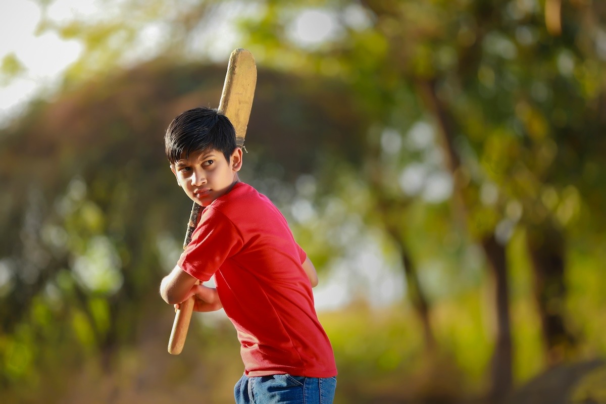 一個印度孩子在玩溝裡板球