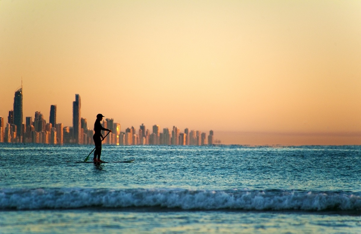 Ein Paddler vor der Skyline der Gold Coast