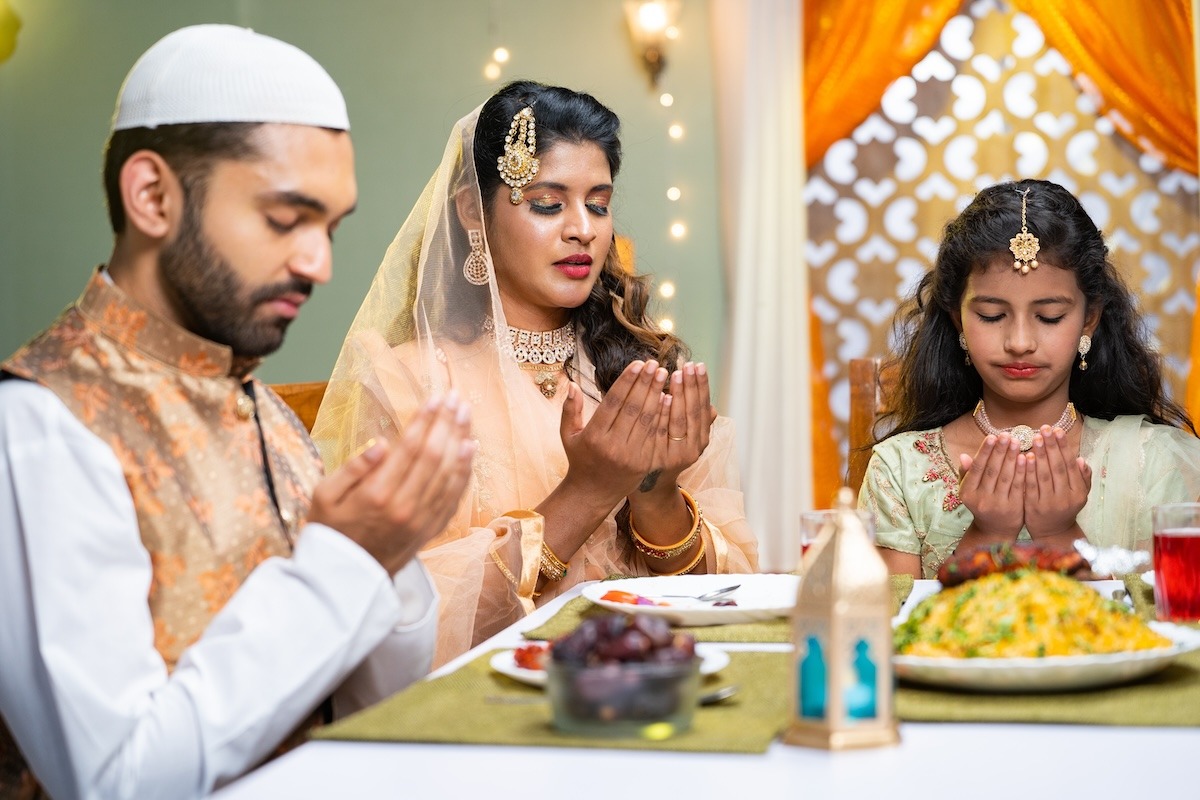 Indische muslimische Familie betet beim Ramadan-Iftar-Essen