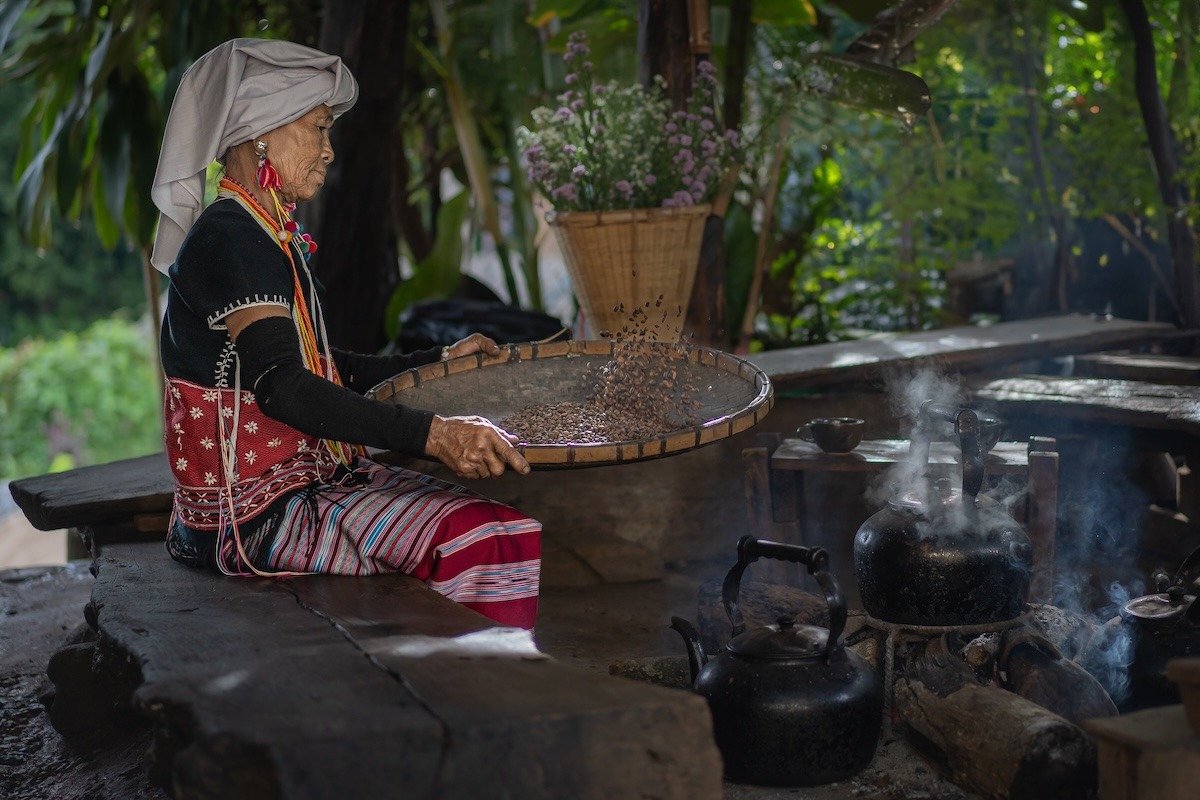 Wanita puak bukit Karen mengasingkan serbuk kopi dengan cara lama, Taman Negara Doi Inthanon, Chiang Mai, Thailand