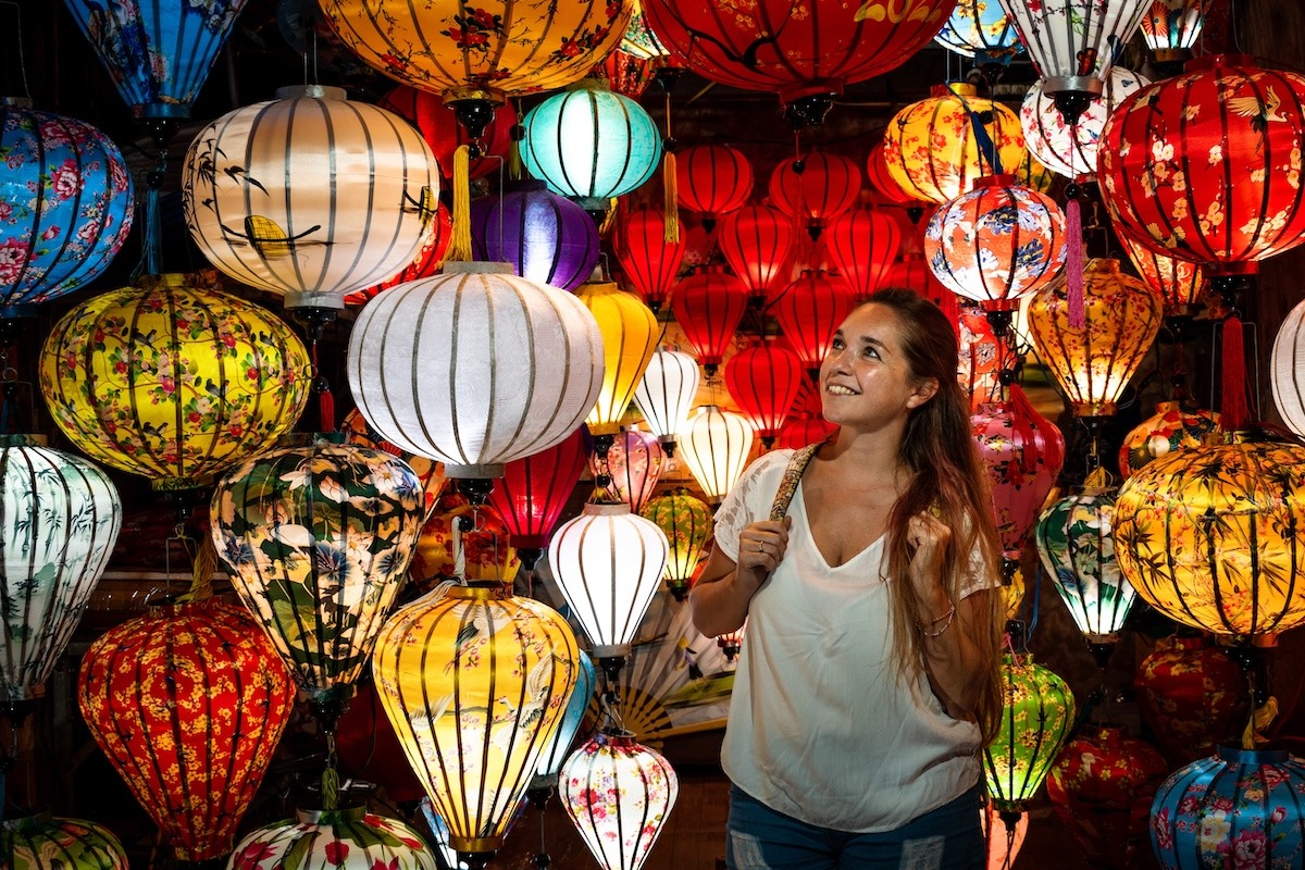 Tourist umgeben von Papierlaternen in Vietnam