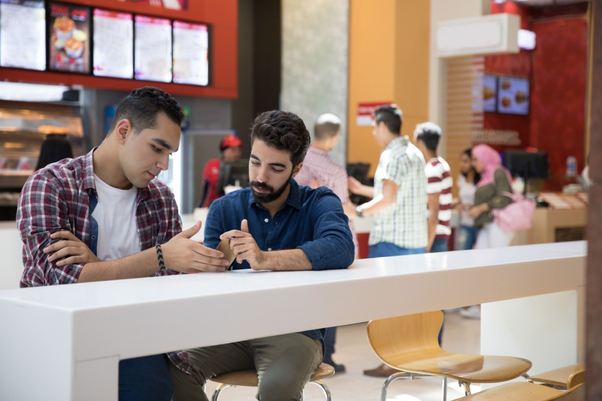 Tourists using phone in food court Tourists using phone in food court